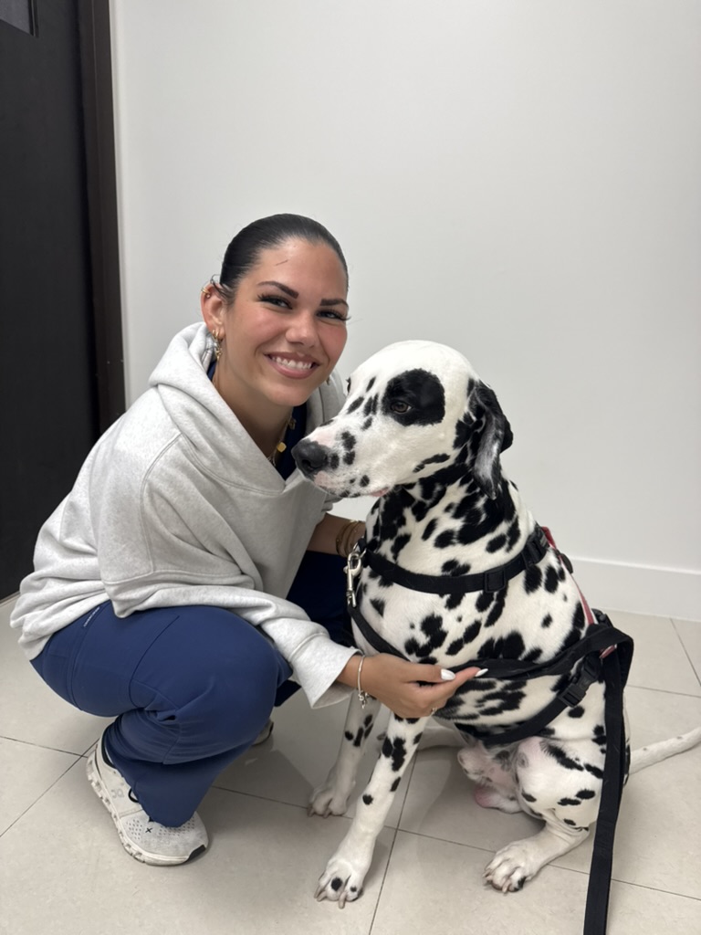 A smiling person with a dalmatian dog